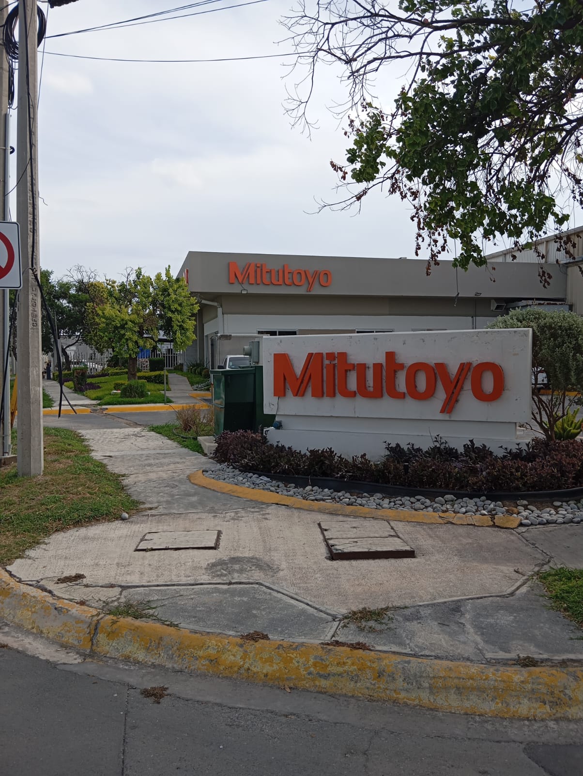 Letrero Mitutoyo con halo cálido — vista con luz apagada