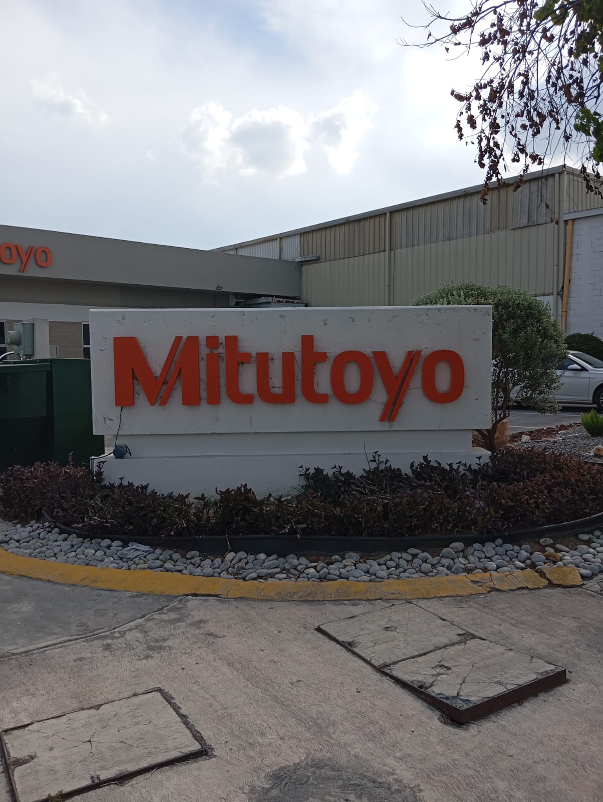 Letrero Mitutoyo con halo cálido — vista 2, luz apagada